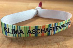 Armband mit der Aufschrift "Klima Aschaffenburg" und einem Design der "warming stripes "der Stadt