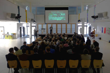 Konferenzsaal mit Teilnehmenden und Vortragenden
