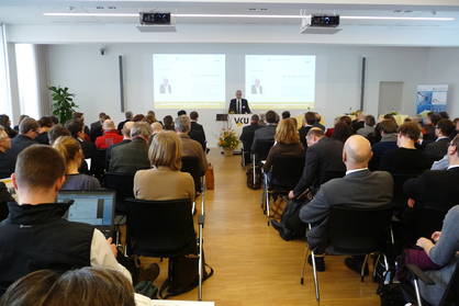 Menschen sitzen auf Stühlen in einem Konferenzraum