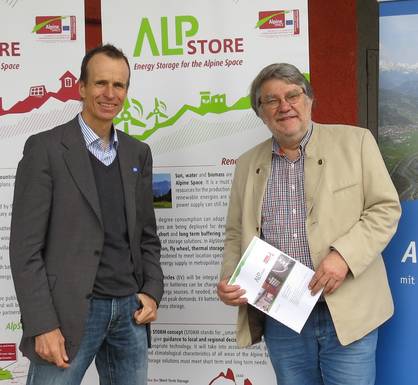 Two persons standing in front of a poster