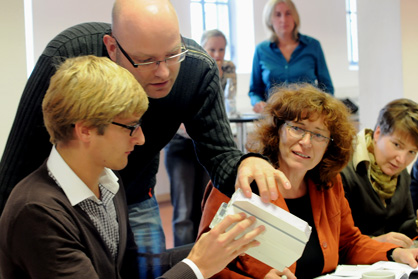 Gemeinsames Erarbeiten von Inhalten im B.A.U.M.-Seminar ((c) B.A.U.M. Consult) Schulungsleiter mit Seminarteilnehmern